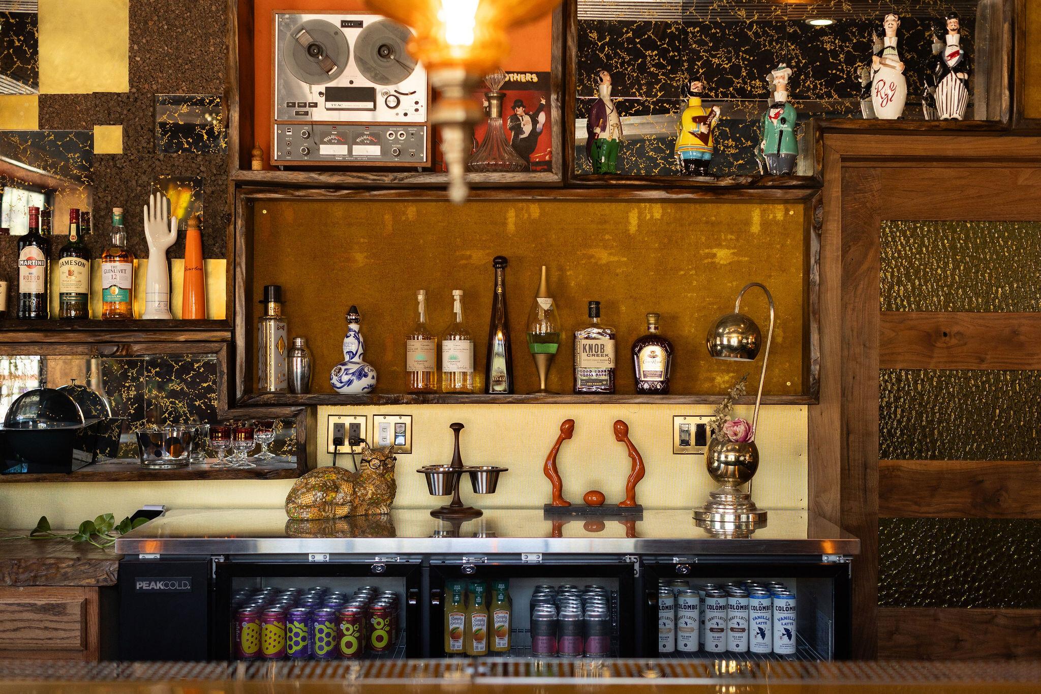 Back bar with reel-to-reel tape player, figurines, and bottles of liquor