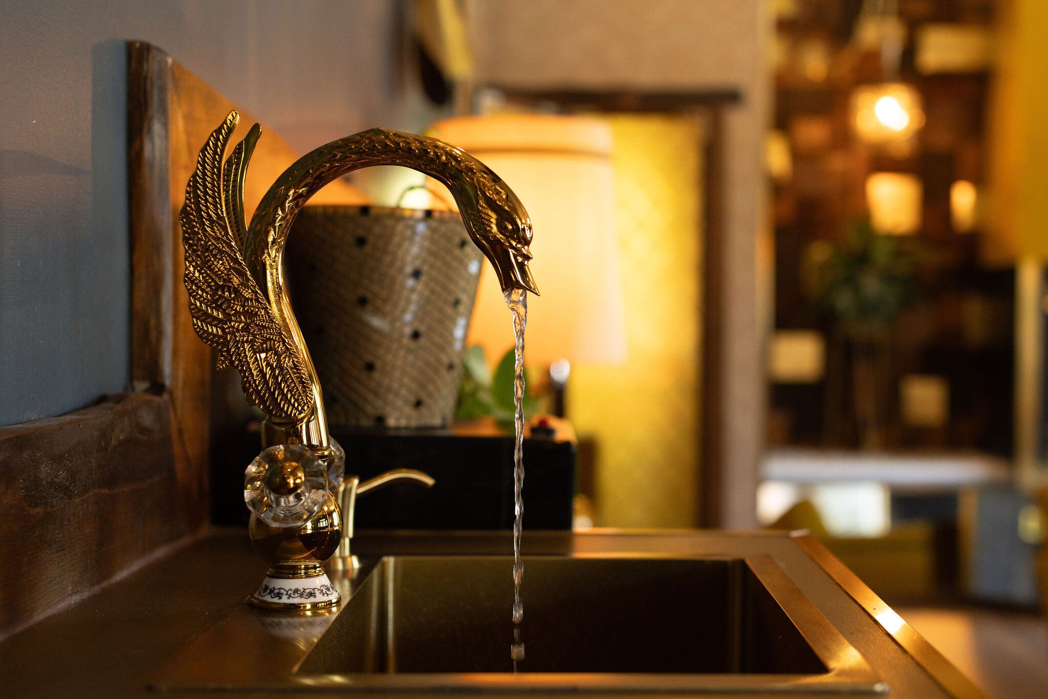 Gilded brass swan faucet over a brass sink in the lounge bar