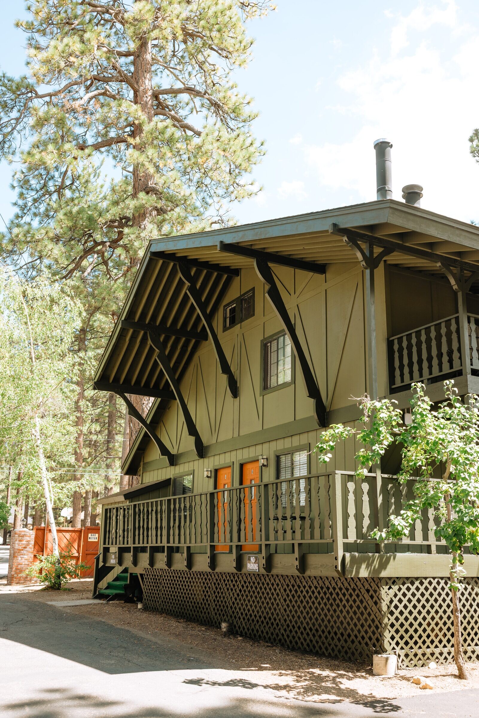 Alpen Haus exterior — green Bavarian chalet with orange door under pines