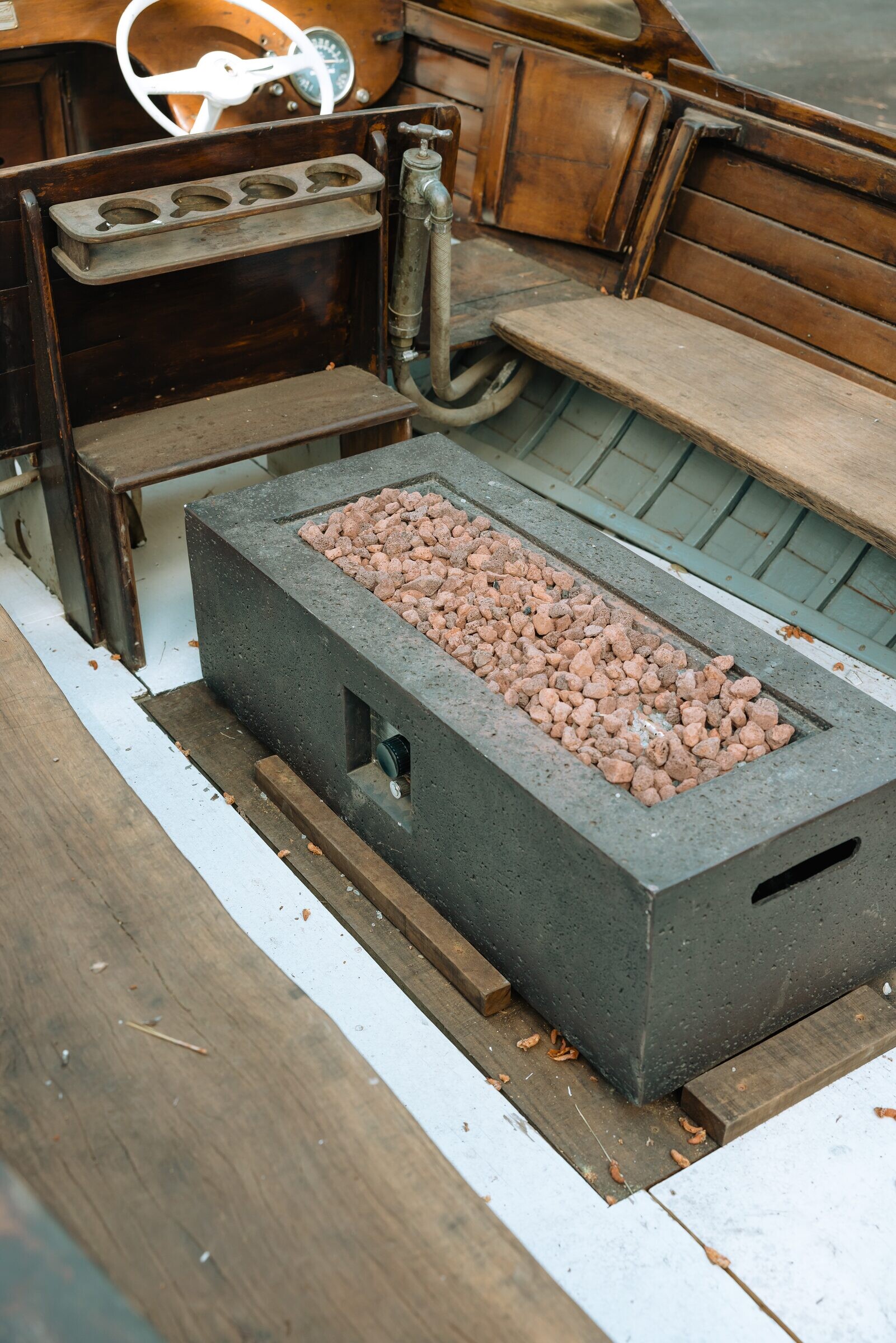 Vintage white boat reborn as an outdoor lava-rock fire pit