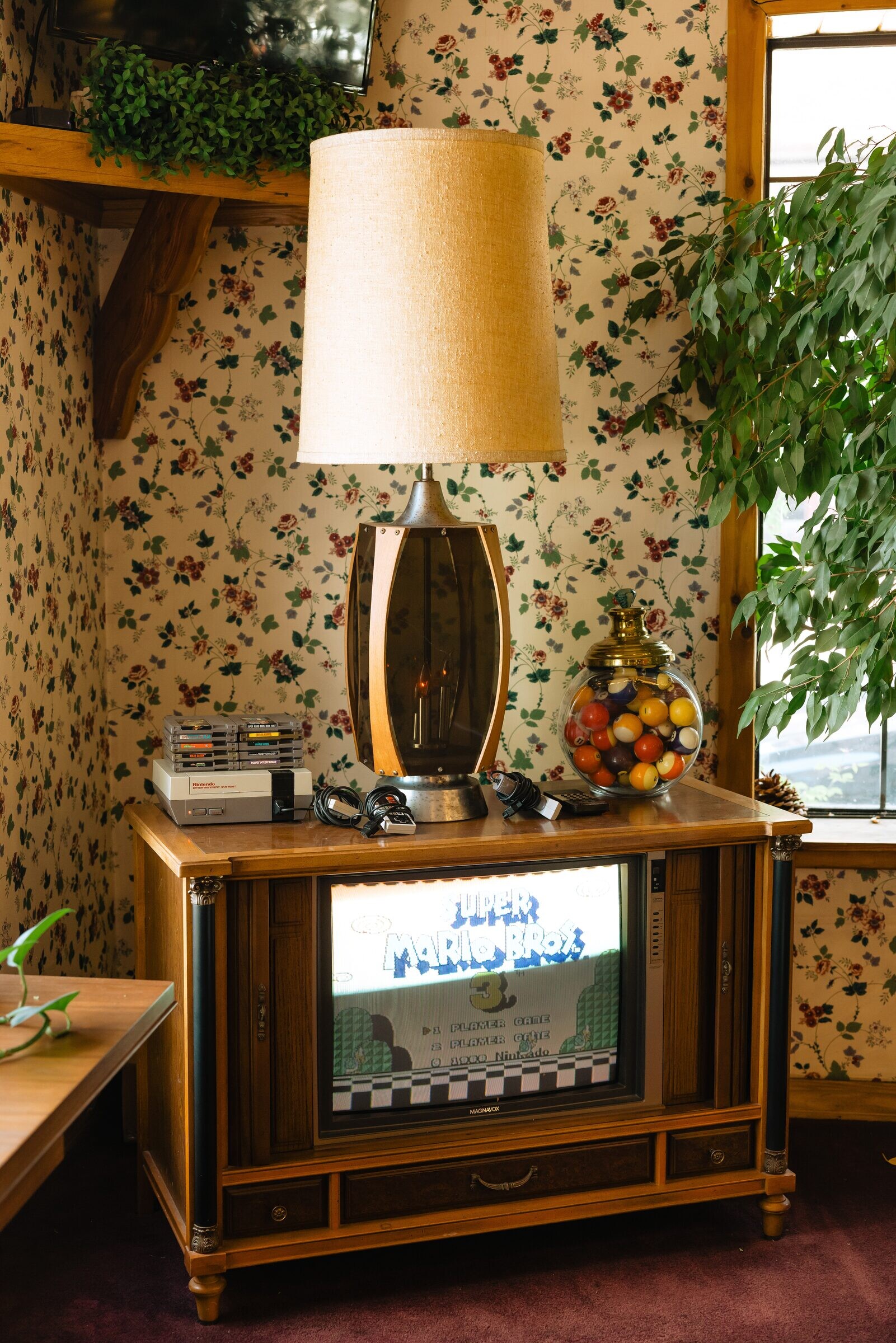 Vintage TV cabinet running Super Mario Bros next to a jelly-bean candy jar