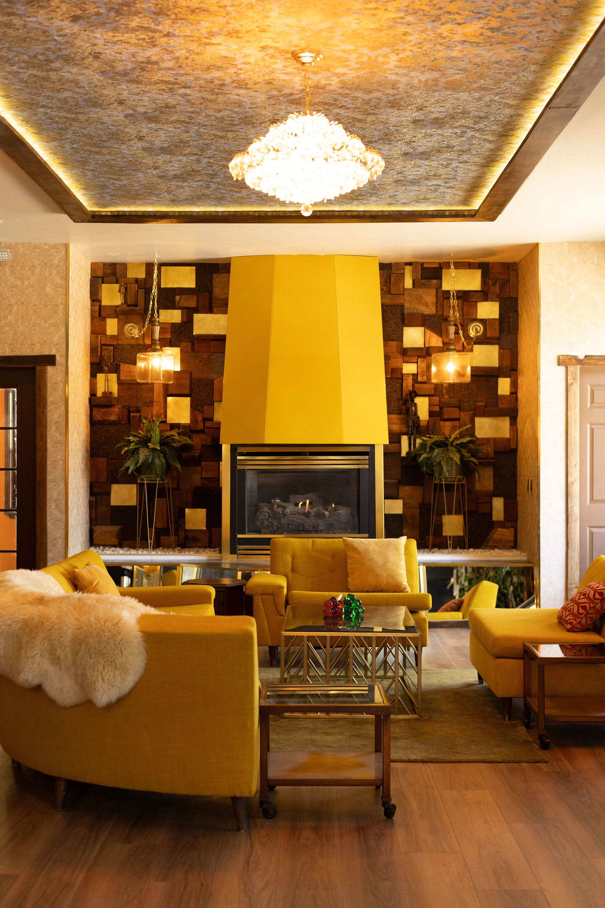 Yellow chesterfield sectionals around a yellow fireplace hood in the lounge