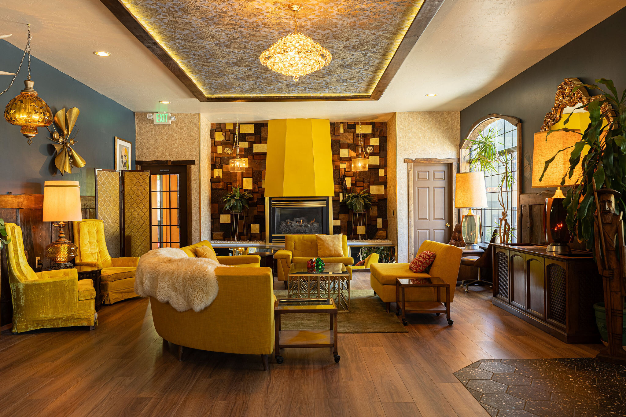 Yellow chesterfield sectional under a yellow fireplace hood with antler art