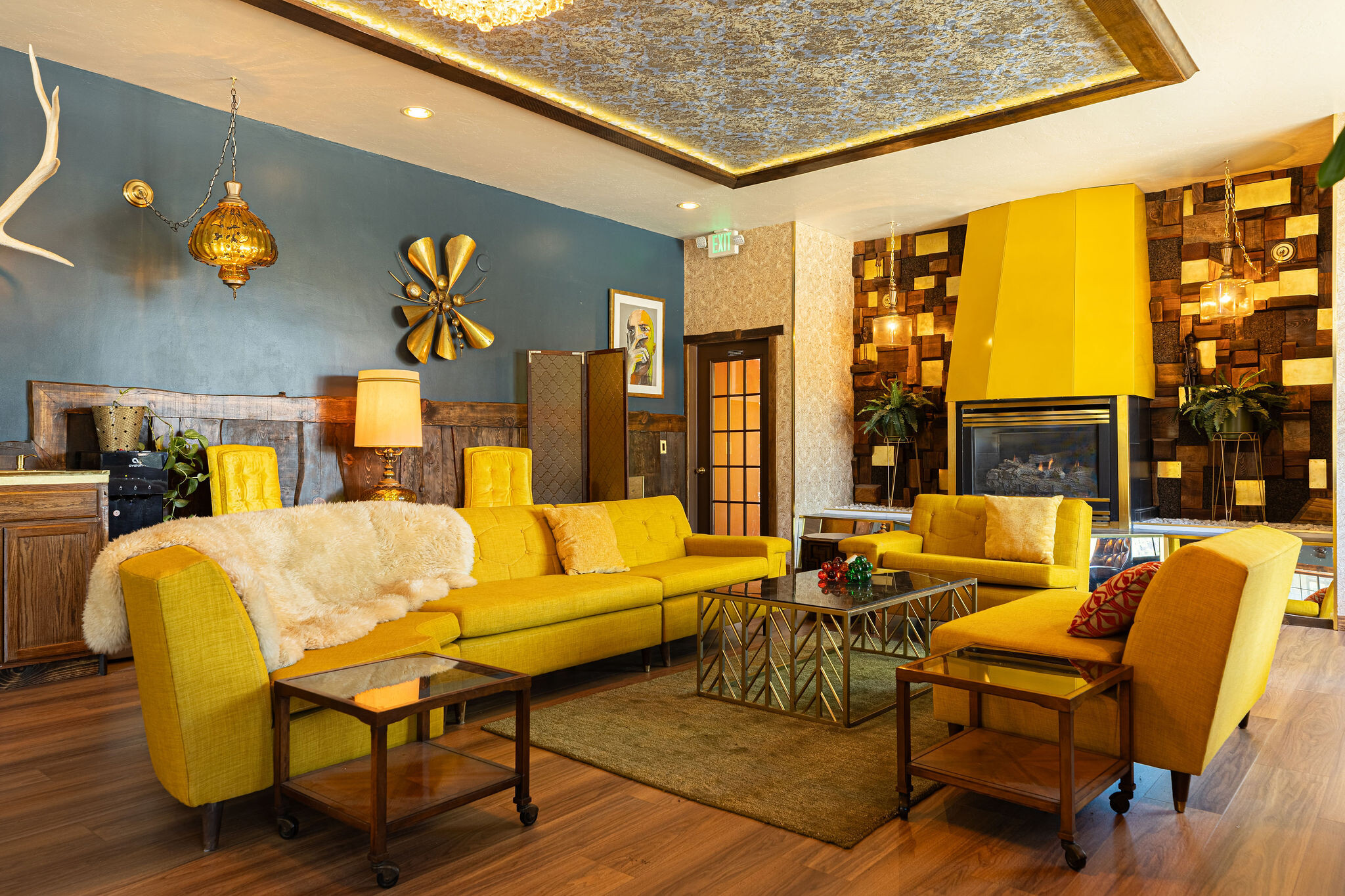 Loft great room with green sofa, kitchen bar, and yellow-lattice stairway